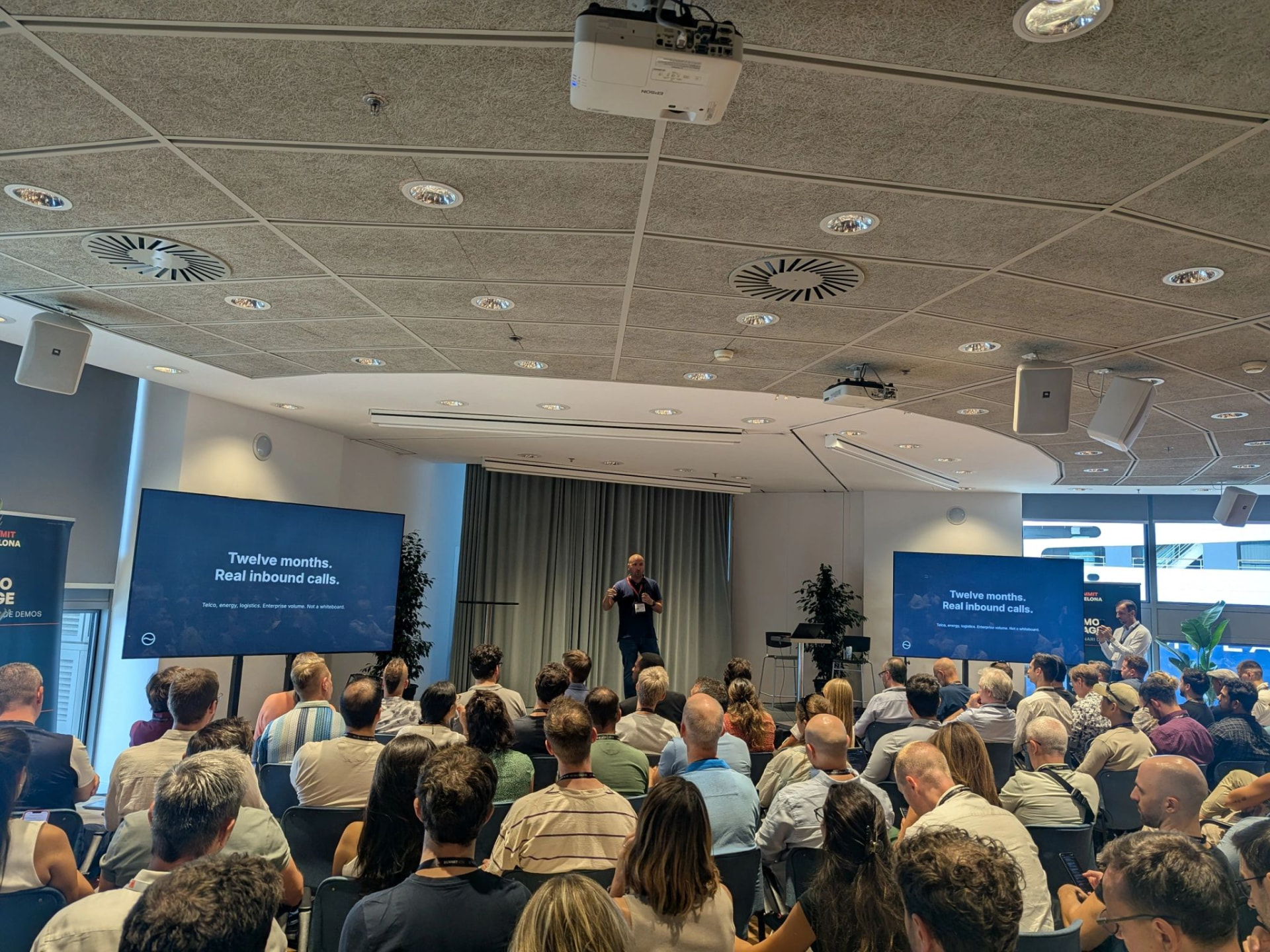 VoiceB slide on the Demo Stage at AI Summit Barcelona 2026: Twelve months. Real inbound calls.